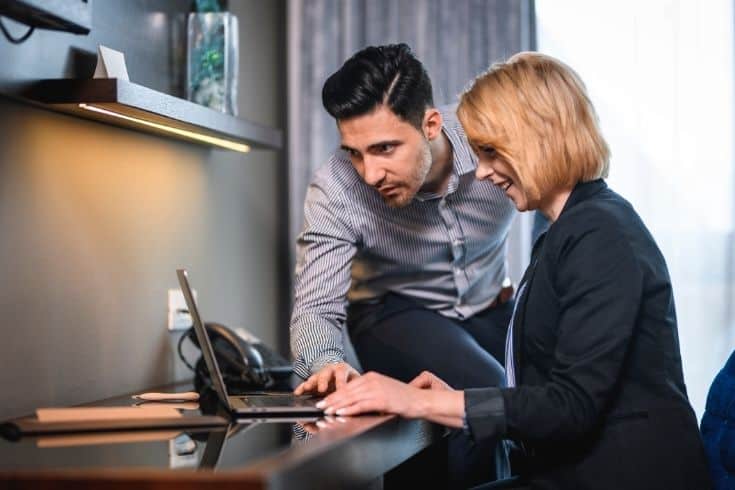 Compatible Businesspeople Working Together in Hotel Room